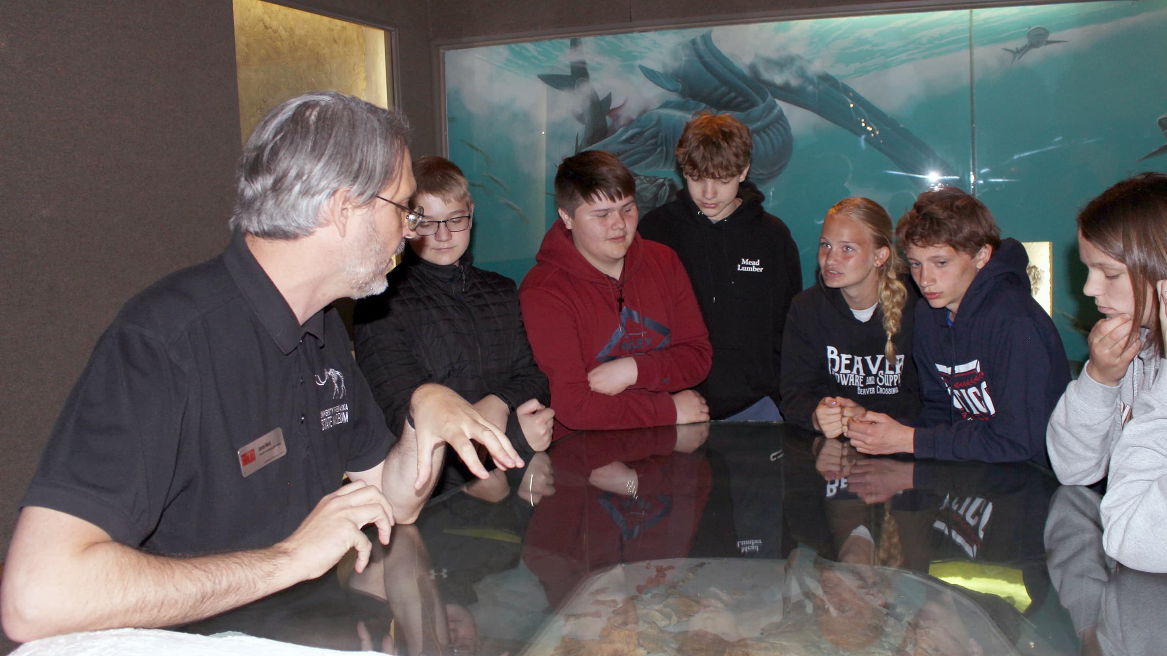 Students learn about a plesiosaur fossil with an educator during a field trip. 