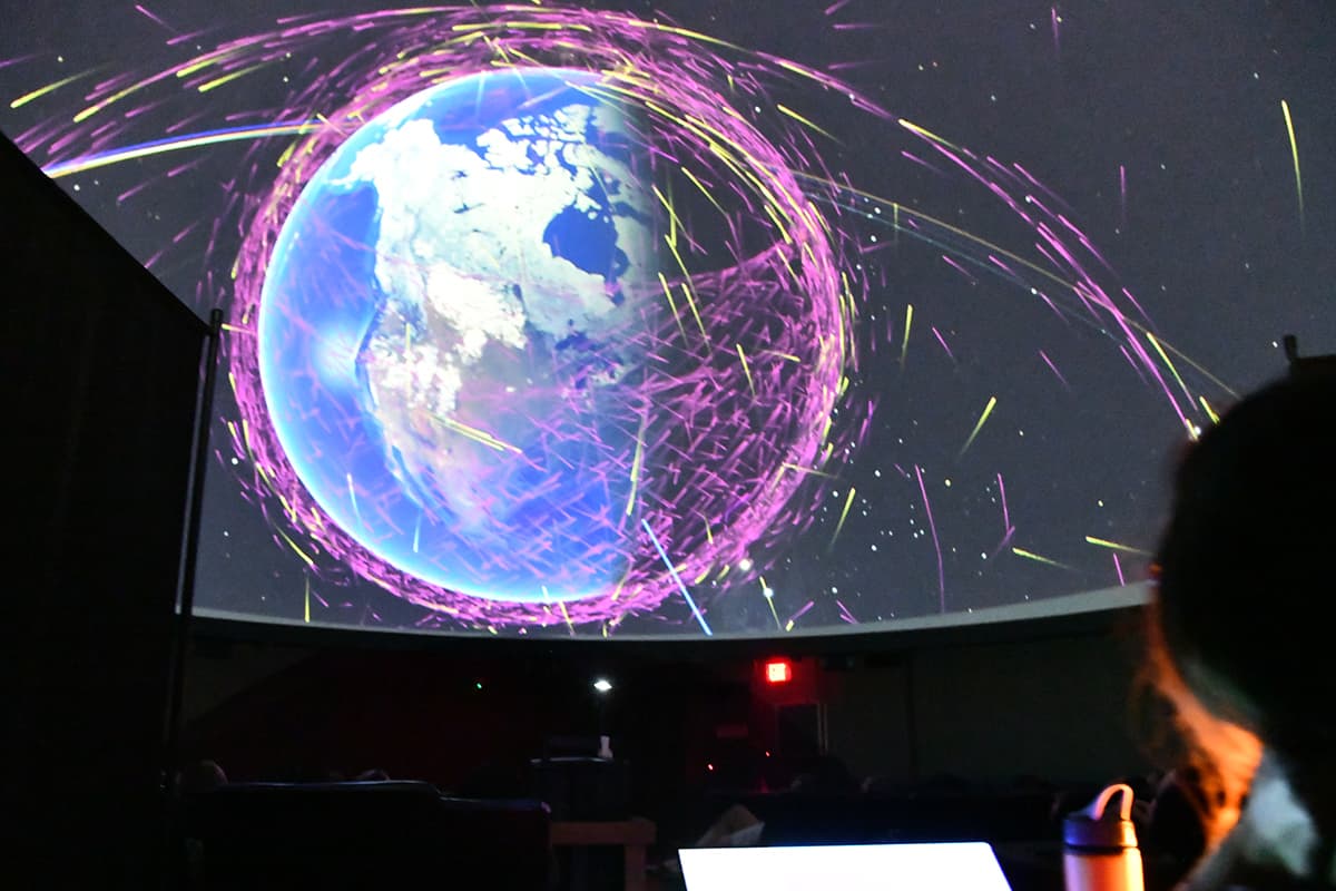 A globe graphic is projected on the fulldome of the Mueller Planetarium.