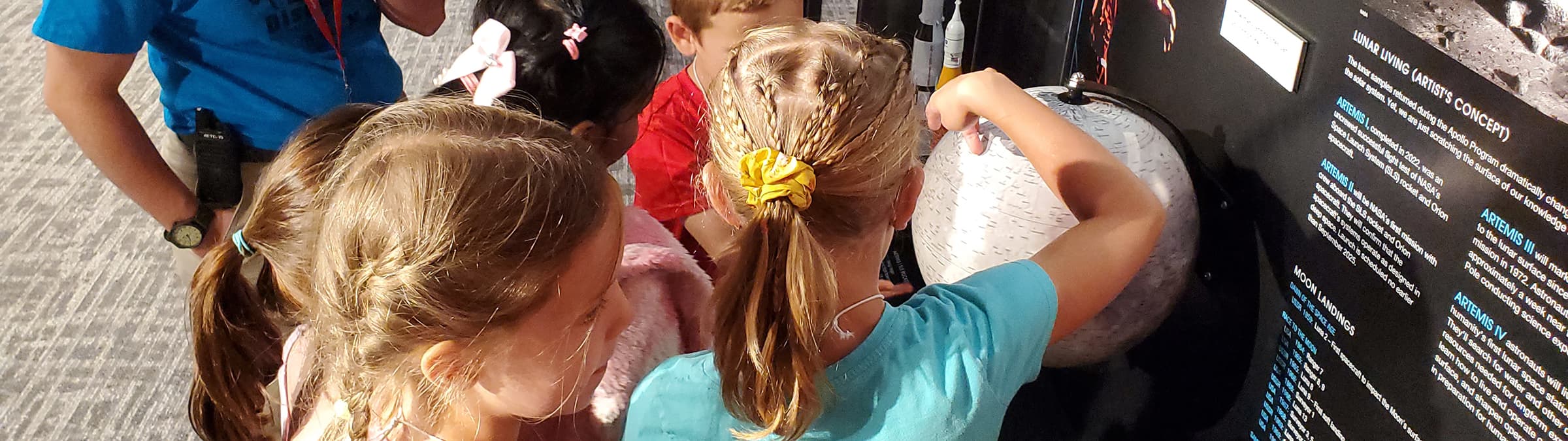 Students examine a globe representation of the moon.