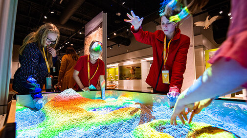 Students playing with the sand of the watershed table in Cherish Nebraska exhibit